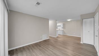 A room with wooden flooring and a white door.